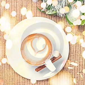 Cup of coffee or chai tea with latte art and Christmas decor. Leasure time concept. Pastel colors. Festive bold bokeh