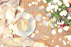 Cup of coffee or chai tea with latte art and Christmas decor. Leisure time concept. Pastel colors. Festive bold bokeh