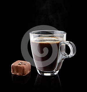 Cup of coffee with a chocolate bonbon