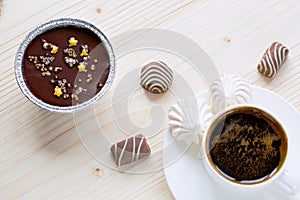 Cup of coffee, chocolates, meringue, a cottage cheese dessert of handwork on a wooden background