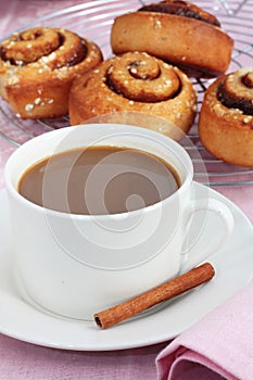 A cup of coffee with cinnamon rolls