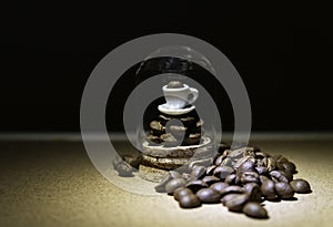 Cup of coffee on coffee bean in glass tube isolated from black background