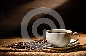 Cup of coffee and coffee beans on burlap sack on old wooden background