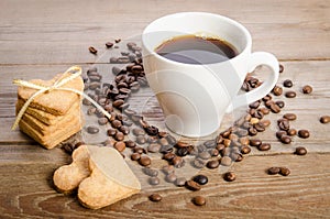 The cup of coffee, coffee beans and cookies-hearts related together