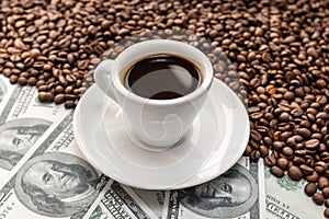 Cup of coffee on Coffee beans and dollar banknotes
