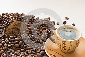 A cup of coffee, coffee beans, ground coffee photo