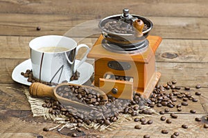 Cup of coffee, coffee beans and old coffee grinder
