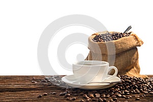 Cup of coffee and coffee beans on old wooden table isolated on white background