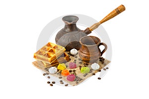 Cup of coffee, coffeepot, waffles, coffee beans and marmalade candy isolated on white