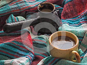 A Cup of coffee and colored textiles. Comfort on cold days. Home comfort.