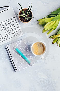 Cup of coffee, with communication device with and writing tools. Flat lay home business desk