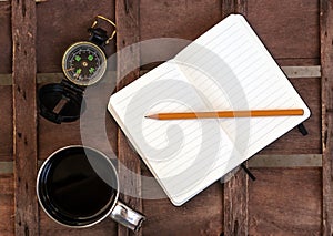 Cup of coffee with compass and notepad