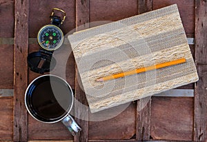 Cup of coffee with compass and notepad