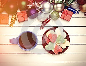 Cup of coffee and cookie with christmas toys on whte background.