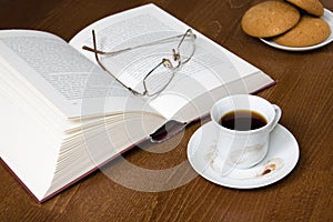 Cup of coffee, cookies, old book & glasses