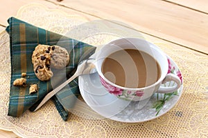 A cup of coffee and cookies on the wood