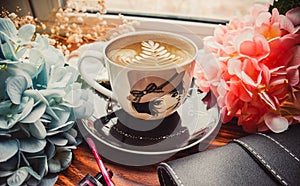 Cup of coffee and cosmetics on wood brown background with handbag	