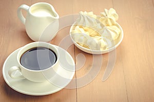 Cup of coffee, creamer and meringue/cup of coffee, creamer and meringue with copy space