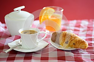 Cup of coffee, croissant, orange juice and a sugar bowl