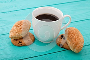 Cup of coffee with croissants on blue wooden table.Selective focus