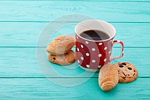 Cup of coffee with croissants on blue wooden table.Selective focus