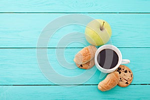 Cup of coffee with croissants on blue wooden table.Selective focus. Copy space and mock up