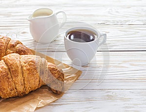 Cup of coffee, croissants, and milk jar