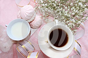 A cup of coffee and a cup of milk on the morning table, dessert and spring flowers