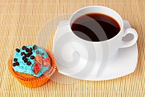 Cup of coffee and cupcake with cream and chocolate drops,