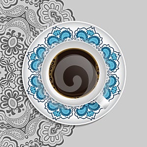 Cup of coffee and decorative ornament on a saucer