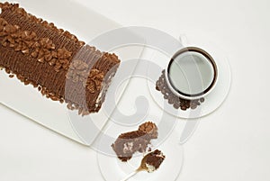 Cup of Coffee and Delicious Chocolate Cake, Metal Spoon and a piece of Cake, on White Background