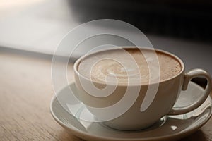 A cup of coffee on desk, Cup of coffee in hand, mug of latte coffee, Close up concept