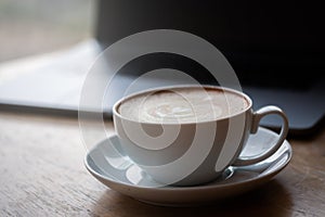 A cup of coffee on desk, Cup of coffee in hand, mug of latte coffee, Close up concept