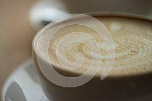 A cup of coffee on desk, Cup of coffee in hand, mug of latte coffee, Close up concept