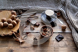 Cup of coffee, different kinds of nuts, walnut, hazelnuts, almonds on old wooden table boards, edible seed kernels, food concept,