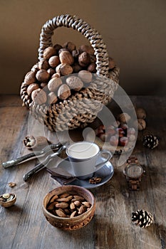 Cup of coffee, different kinds of nuts, walnut, hazelnuts, almonds on old wooden table boards, edible seed kernels, food concept,