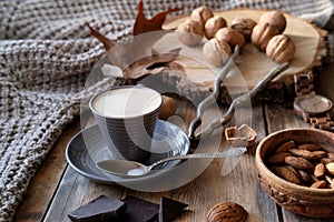 Cup of coffee, different kinds of nuts, walnut, hazelnuts, almonds on old wooden table boards, edible seed kernels, food concept,