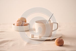 Cup of coffee with donuts for breakfast on light background