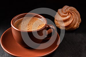 Cup of coffee with eclairs on a stone background. Top view with copy space for your text