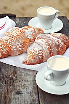 A cup of coffee espresso and croissant