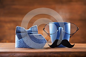 Cup of coffee, eyeglasses, mustache and bowtie for creative breakfast on Happy Fathers Day. Greeting card for daddy