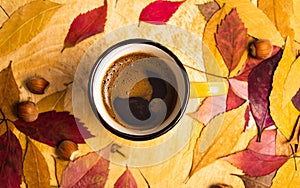 Cup of coffee in and fallen leaves