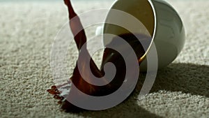 Cup of coffee falling and spilling over carpet