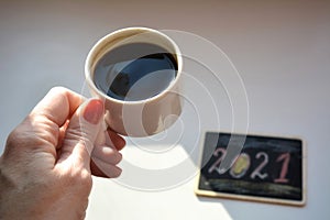 Cup of coffee in the female hand white background