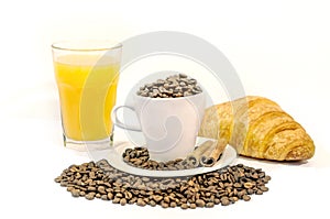 Cup of coffee filed with coffee beans with croissants, two cinnamon stick