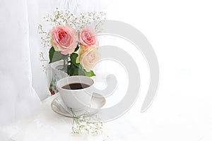 A cup of coffee and flowers on a light background