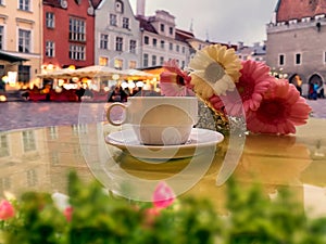 Cup of coffee and flowers  table top in Tallinn old town medieval city stree town hall square photo