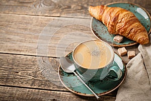 Cup of coffee and fresh croissant