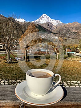 Cup of coffee in front of beautiful snow mountain panorama