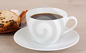 Cup of coffee and fruitcake on a saucer.